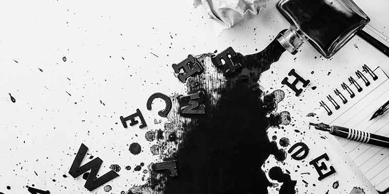 Header with spilled ink, crumpled paper, scattered letters, papers and notepads on a white wooden background. Creative writing concept. Flat lay with copy space.