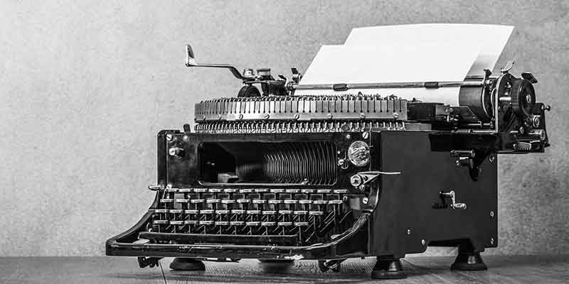 Vintage old aged black typewriter circa 40s with paper blank on